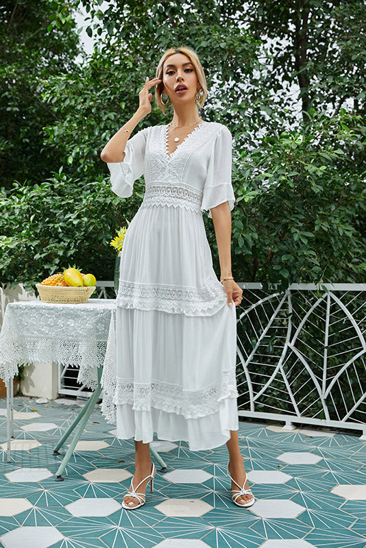 Mujer joven en un jardín con un vestido blanco ibicenco