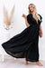 Mujer rubia con un vestido ibicenco negro y un clutch de cuero para la noche