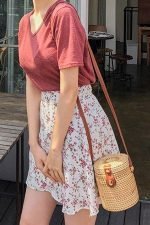 Mujer luciendo una falda y un top colorido con un bucket bag adlib