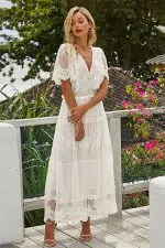 Mujer con un vestido blanco largo en la playa de ibiza