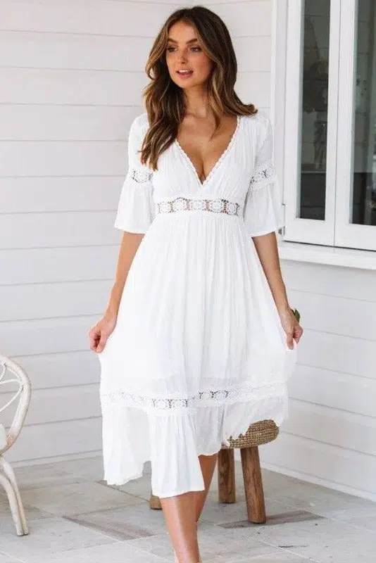 Mujer con vestido adlib largo delante de una casa