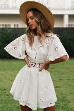 Mujer joven con vestido blanco corto al estilo ibicenco