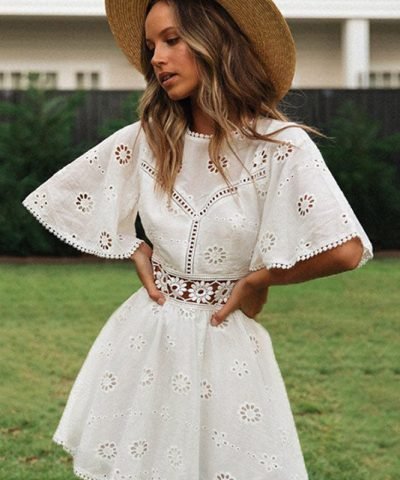 Mujer joven con vestido blanco corto al estilo ibicenco