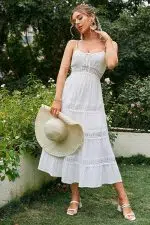 Mujer luciendo un vestido de fiesta ibicenca color blanco con sombrero
