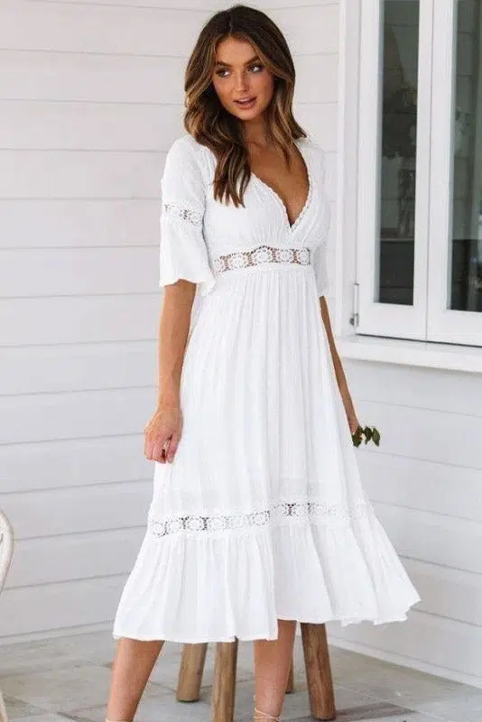 Joven mujer morena con sandalias y vestido blanco largo