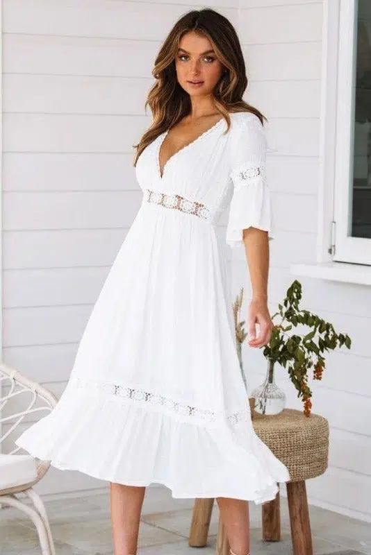 Mujer morena haciendo girar su vestido ibicenco blanco