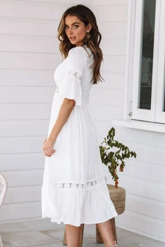 Mujer de pie y de espaldas con vestido blanco en Ibiza