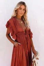 Vestido largo rojo de estilo ibicenco acompanado de un bolso y varios collares
