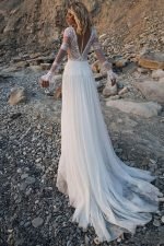 Vestido de novia hippie e ibicenco en una playa de guijarros